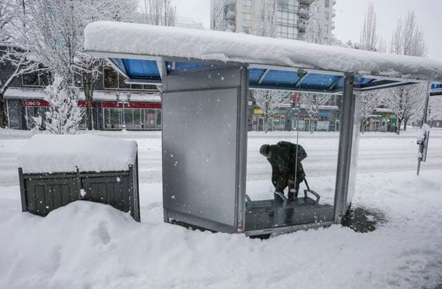 (240117) -- VANCOUVER, Jan. 17, 2024 -- A person waits at a bus stop covered with snow in Vancouver, British Columbia, Canada, on Jan. 17, 2024. Environment Canada issued a snowfall warning for the province of British Columbia on Wednesday. The Metro Vancouver region saw up to 20 centimetres of snow, causing schools to close and flights to be delayed and cancelled. (Photo by Xinhua) CANADA-VANCOUVER-HEAVY SNOW LiangxSen 