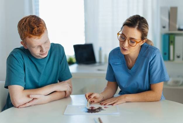 Teenager taking Rorschach test during psychological therapy with adolescent psychologist. Psychological session for teenage boy. Concept of teen mental health and unique adolescent behaviour, problems. Teenager taking Rorschach test during psychological therapy with adolescent psychologist. Psychological session for teenage boy. Concept of teen mental health and unique adolescent problems. model released Copyright: xx HHH TEEN HEALTHCARE 2023 HHH 057