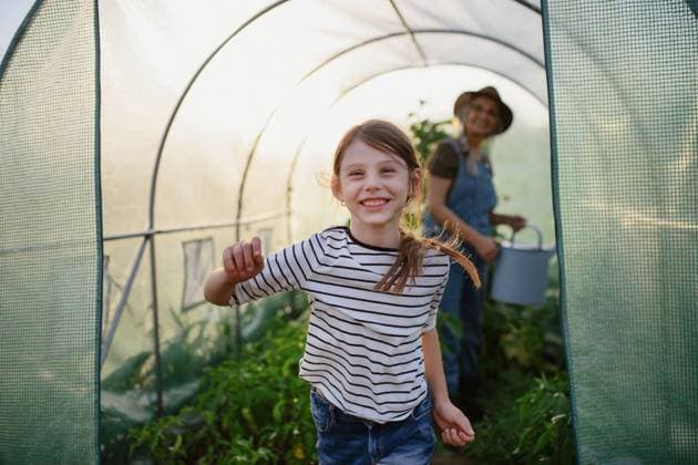 IMAGO Creative: Sommer, Sommertage im Garten Portrait of happy little farmer girl with grandmother in greenhouse, looking at camera. A portrait of happy little farmer girl with grandmother in greenhouse, looking at camera. model released Copyright: xx Community_Farming_II_2021_382