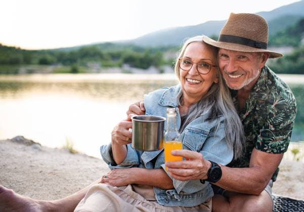 Happy senior couple on hiking trip on summer holiday, relaxing by lake. A happy senior couple on hiking trip on summer holiday, relaxing by lake. model released Copyright: xx Family_Lake_Holidays_2021_278