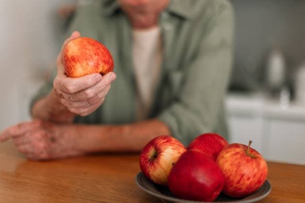 Close-up of senior man holding apples in his kitchen. Close-up of senior man holding apples in a kitchen. model released Copyright: xx SENIORS SPRING MOOD 202254