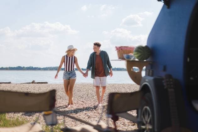 Young couple in front of van during summer vacation. Young couple in front of van during summer holiday. model released Copyright: xx SUMMER WATER TRIP COUPLE 202237