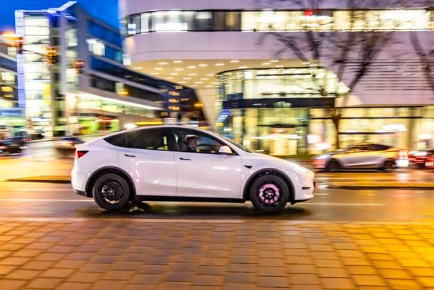 Inner-city street with vehicles, modern architecture in the evening Motion blur Tesla Model Y 17 01 2024 Stuttgart, Baden Württemberg, Germany