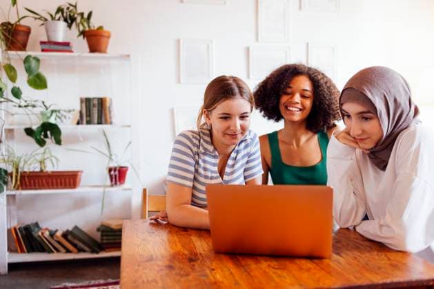 Three pretty female teenagers of different nationalities are looking at the laptop screen and laughing Three pretty female teenagers of different nationalities are looking at the laptop screen and laughing. Caucasian, afro american and muslim teens are watching a webinar or chatting at the computer ,model released, Symbolfoto Copyright: xZoonar.com DashaxPetrenkox 20838996 ,model released, Symbolfoto ,property released