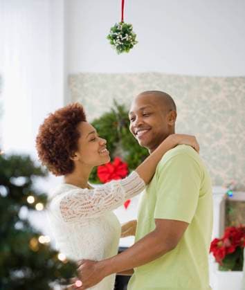 African couple kissing underneath mistletoe Jersey City, NJ, 21.12.2023, model released, TTBB_BLD065875.jpg, 20-24 years, 25-29 years, african ethnicity, afro, anticipation, boyfriend, christmas, color image, decoration, devotion, domestic life, enjoying, face to face, festive, flirting, girlfriend, happy, heterosexual couple, holiday, hugging, indoors, kissing, lifestyle, love, man, mistletoe, mixed race person, people, photography, romance, side view, standing, tradition, two people, vertical, waist up, woman, wreath, young adult, young couple, young men, young women, minority, minorities2, 20s, 20-25, 20-30, 20s, 25-30, adoring, adult, affection, affectionate, african, african american, african-american, afro american, afro-american, ap Copyright: xJGI JamiexGrillx
