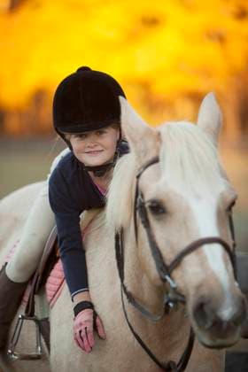 IMAGO Creative, Kinder auf dem Reiterhof Caucasian girl riding on horse Manakin, VA, Goochland, 21.12.2023, property released, TTBB_BLD086202.jpg, 8-9 years, affection, animals, autumn, bonding, bridle, caucasian, caucasian, childhood, color image, confidence, day, devotion, elementary age, enjoying, focus on foreground, friend, front view, girl, girls, grinning, happy, helmet, holding, horse, horseback riding, horsemanship, hugging, innocence, laying, leaning, leisure activity, looking at camera, nature, one animal, one person, outdoors, people, photography, portrait, pride, protection, recreation, rural scene, safety, skill, smiling, three quarter length, together, transportation, vertical, weekend activities, ability, accessory, affectionate, amusement, animal, apparel, appre Copyright: xJohnxHenleyx