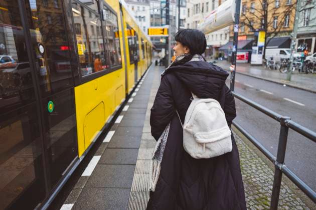 Woman with backpack walking near cable car at tram station model released, Symbolfoto, JCCMF11089