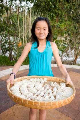 IMAGO Creative, Food, Dumplings Chinese girl holding basket of dumplings Alta Loma, California, United States, 21.12.2023, model released, TTBB_BLD088787.jpg, 8-9 years, asian ethnicity, black hair, childhood, chinese ethnicity, color image, day, domestic kitchen, domestic life, dumpling, elementary age, food and drink, front view, girl, girls, happy, healthy eating, healthy living, holding, lifestyle, looking at camera, one person, outdoors, patio, people, photography, portrait, posing, presenting, pride, smiling, standing, three quarter length, tradition, traditional culture, tray, vertical, minority, minoritiesasian, cheerful, child, children, color, colour, culture, custom, daylight, daytime, enjoyment, far eastern, female, food, gaiety, gal, glad, gleeful, human, hu Copyright: xJacquelinexVeissidx