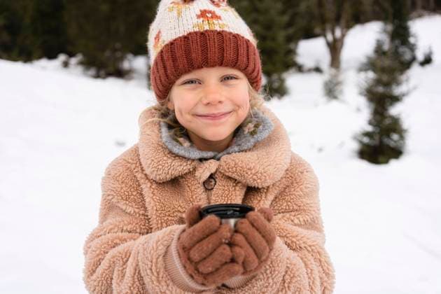 Smiling girl holding tea in winter forest model released, Symbolfoto, SVKF01792