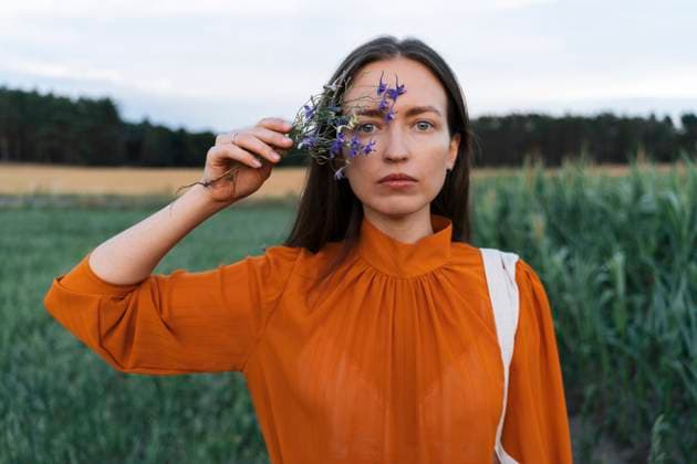 Woman holding blue flower in field model released, Symbolfoto, TOF00188