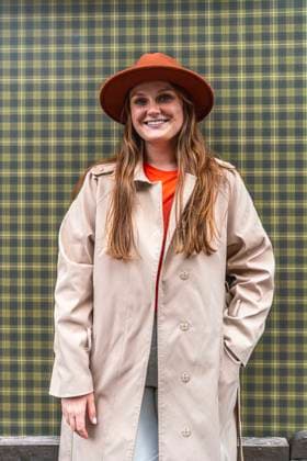Happy woman wearing hat and standing in front of checked wall model released, Symbolfoto, VPIF09038