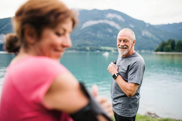 Senior pensioner couple runners with smartphone by lake in nature. Senior pensioner couple runners with smartphone by lake in nature, resting. model released Copyright: xx Austria_Cvancarovci_II_2019_672