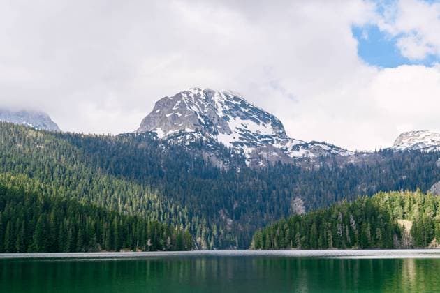 Black lake overlooking the snow-capped peak of Mount Bobotov Kuk. Durmitor National Park, Montenegro Black lake overlooking the snow-capped peak of Mount Bobotov Kuk. Durmitor National Park, Montenegro. High quality photo Copyright: xZoonar.com NadtochiyxVladimirx 20950117