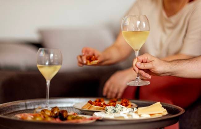 Two glasses of cool champagne and plates with various snacks on a round metal coffee table Two glasses of cool champagne and plates with various snacks on a round metal coffee table. White plates with slices of ham, salami, capers, olives and cheese. Cozy interior of the living room of the house. ,model released, Symbolfoto Copyright: xZoonar.com DashaxPetrenkox 20958809 ,model released, Symbolfoto ,property released