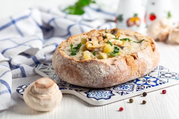 Potato-mushroom soup in a loaf of bread. Delicious homemade potato soup with mushrooms in a loaf of bread served with fresh parsley, selective focus. Copyright: xZoonar.com MarinaxSaprunovax 21000379