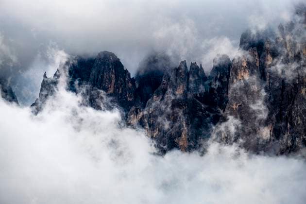 Rising clouds after a rain shower surrounding the rock cliffs around the summits of Grohmannspitze and Fünffingerspitze, seen from Seiser Alm, Alpe di Siusi. Kastelruth Trentino-Alto Adige Italy FB_2023_2942