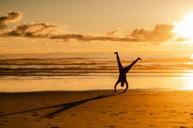 Creative Highlights Symbolbilder Man Doing Sunset Handstand on Beach Rockaway Beach, Oregon, United States R_BQMG240124-1340801-01 ,model released, Symbolfoto