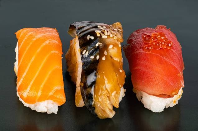 Closeup view of three kinds of fish sashimi sushi on dark background. Closeup view of three kinds of fish sashimi sushi on dark background. High angle view of Japanese seafood sushi on black. Copyright: xZoonar.com VeeravongxxKomalamenax 20070001