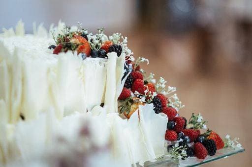 A closeup shot of a white cake with berries and floral decorations 2763419 RECORD DATE NOT STATED