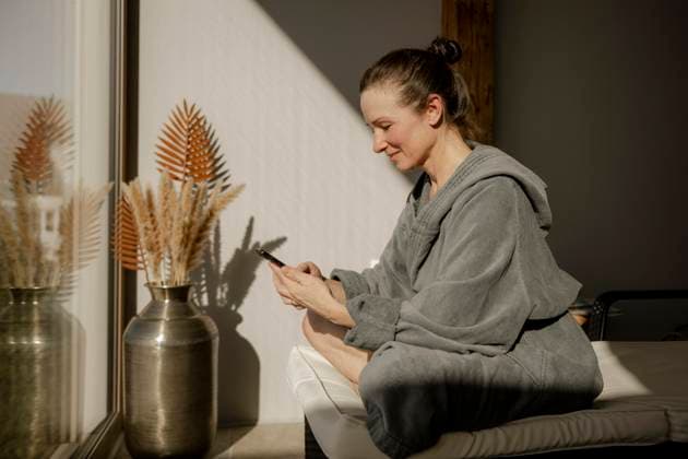 Creative Highlights Symbolbilder Frau im Bademantel sitzt mit Handy in einem Ruheraum beim Wellnessen *** Woman at Bathrobe sits with Handy in a Relaxation room at Wellness Copyright: imageBROKER/MichaelaxBegsteiger ibxbeg10116953.jpg ,model released, Symbolfoto ,property released