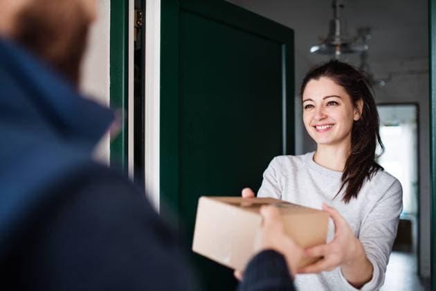 Woman receiving parcel from delivery man at the door. Woman receiving parcel from unrecognizable delivery man at the door - courier service concept. model released Copyright: xx Kurier_023