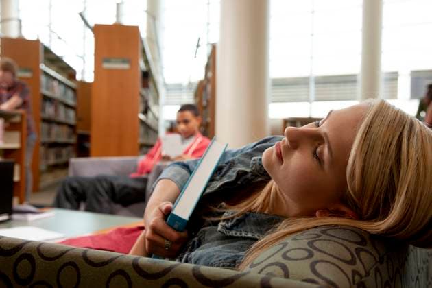 College girl sleeping in library with textbook in hands, exhausted. Dallas Texas United States  Copyright: xStewartxCohenxPicturesx 4009-19483104 ,model released, Symbolfoto