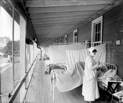 Spanish Flu 1918 - 1919 : Walter Reed Hospital, Washington, D.C. 1725288 Spanish Flu 1918 - 1919 : Walter Reed Hospital, Washington, D.C. by Harris & Ewing (1905-45); (add.info.: Patients are set up in rows of beds on an open gallery, seperated by hung sheets. A nurse wears a cloth mask over her nose and mouth.). Copyright: xBridgemanxImagesx 1725288