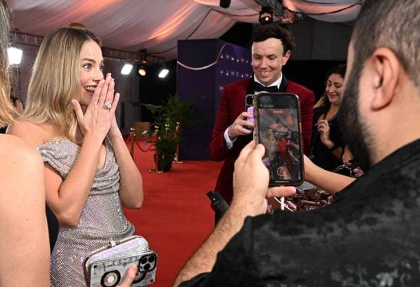 Entertainment Bilder des Tages 2024 AACTA AWARDS, Margot Robbie reacts after being given a packet of Tim-Tams on the Red Carpet for the 2024 Australian Academy of Cinema and Television Arts (AACTA) Awards at HOTA in Surfers Paradise, Queensland, Saturday, February 10, 2024. ( NO ARCHIVING, EDITORIAL USE ONLY, NO USE IN BOOKS WITHOUT CONSENT BRISBANE QLD AUSTRALIA  Copyright: xDARRENxENGLANDx 20240210001900406444