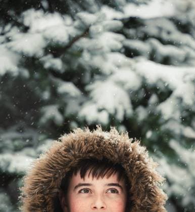 Happy boy wearing coat with furry hood outside in snow on winter day. Kingston, Ontario, Canada CR_DOHO240207I-1345049-01 ,model released, Symbolfoto