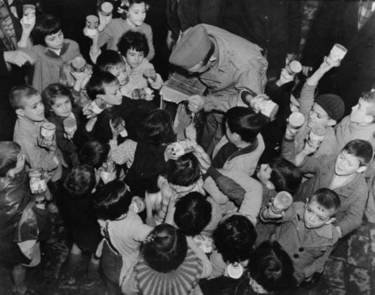 U.S. Army Sergeant Paul Myers of Kansas city, Missouri distributing cans of milk to children in Oran, Algeria, c.1942 3616042 U.S. Army Sergeant Paul Myers of Kansas city, Missouri distributing cans of milk to children in Oran, Algeria, c.1942 by American Photographer, (20th century); Private Collection; (add.info.: Operation Torch (initially Operation Gymnast) was the British-United States invasion of French North Africa during the North African Campaign of the Second World War which started on 8 November 1942.). Copyright: xBridgemanxImagesx 3616042