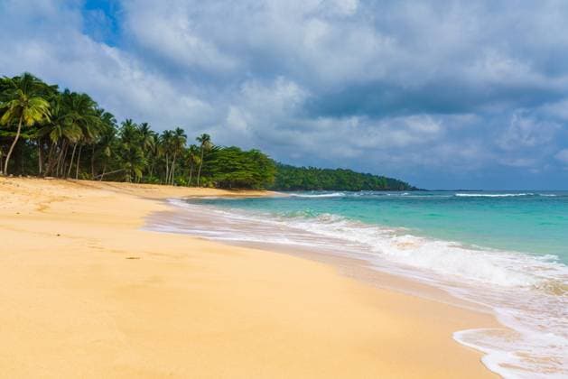 Tranquil sandy shore of Praia Emilia with gentle waves and tropical palms under a cloud-filled sky, encapsulating paradise. Model Released AddventurePhoto_ID19103_568061_027 Copyright: xAddventurexPhotox RECORD DATE NOT STATED