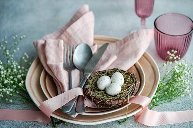 IMAGO Creative, Ostern, Bräuche, Osterbrunch Elegant Easter table setting with pastel-colored napkins, plates, and decorative eggs nested in a twig nest, complemented by flowers and ribbon. Model Released AnnaBogush_ID19406_575238_004 Copyright: xAnnaxBogushx