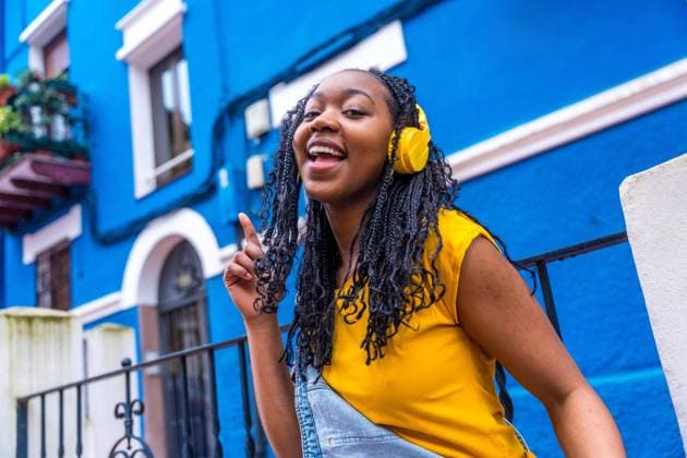 Afrikanische Frau singt in die Kamera und tanzt auf der Straße neben einem blauen Haus *** African Woman sings in the Camera and dances at the Street next to a blue House Copyright: imageBROKER UnaixHuizi ibxuhu10199495.jpg ,model released, Symbolfoto ,property released