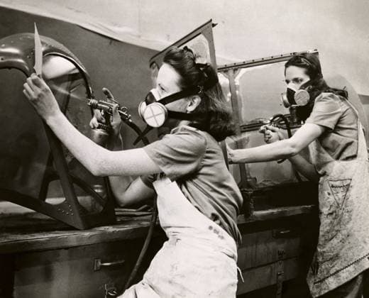 Side profile of two young women spray painting in a factory  Copyright: xx 990-1056
