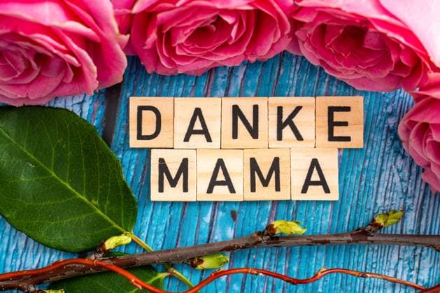 February 21, 2024: Thank you mom! Greeting on wooden cubes next to pink roses. Mother s Day symbol image *** Danke Mama! Gruß auf Holzwürfeln neben rosa Rosen. Muttertag Symbolbild