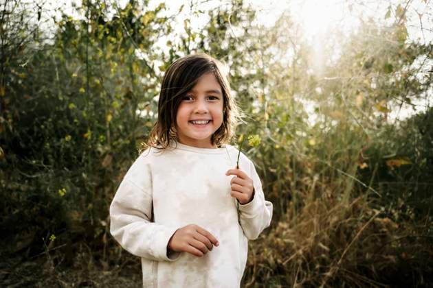 Creative Highlights Symbolbilder Asian girl holding a flower in a field with sun shining Huntington Beach, California, United States CR_RASI24022072-1354248-01 ,model released, Symbolfoto