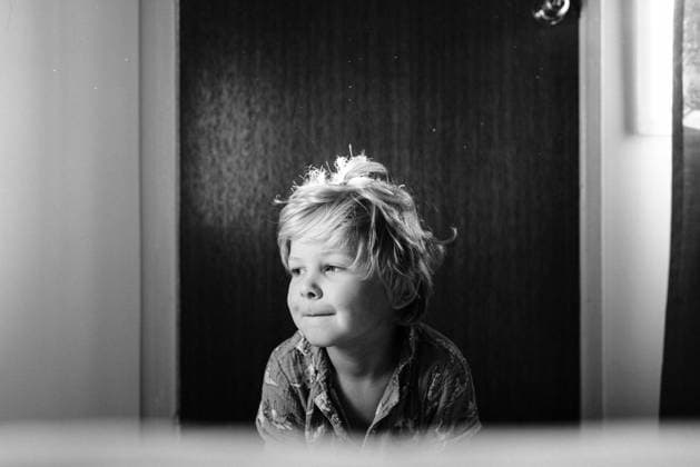 Creative Highlights Symbolbilder Blonde boy with smirk sitting indoors in a motel room Bororen, Queensland, Australia CR_OELC240214-1353580-01 ,model released, Symbolfoto