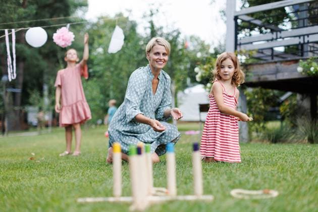 Woman playing with girl in the garden, outdoor garden games, sitting on grass. Woman playing with daughtere in the garden, outdoor garden games, sitting on grass. model released