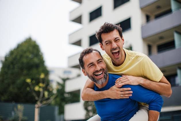 Best friends playing sport outdoors, having fun. Celebratin goal, carrying friend on back, piggyback. Concept of male friendship, bromance. Best friends playing sport outdoors, having fun. Celebratin goal, carrying friend on back, piggybacking. Concept of male friendship, bromance. model released