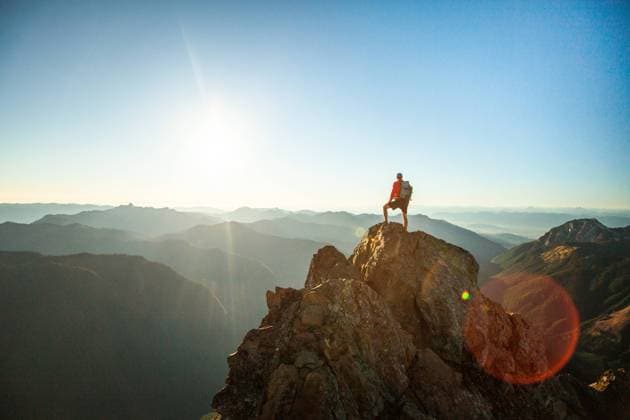 successful hiker wearing backpack stands on mountain summit, sunset Glacier, Washington, United States CR_JDIP240227-1346412-01 ,model released, Symbolfoto