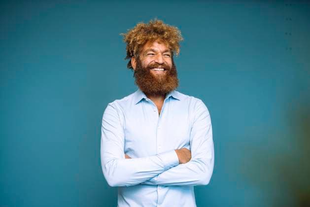 Creative Highlights Symbolbilder Happy mature businessman with arms crossed standing in front of blue wall model released, Symbolfoto property released, JOSEF23340