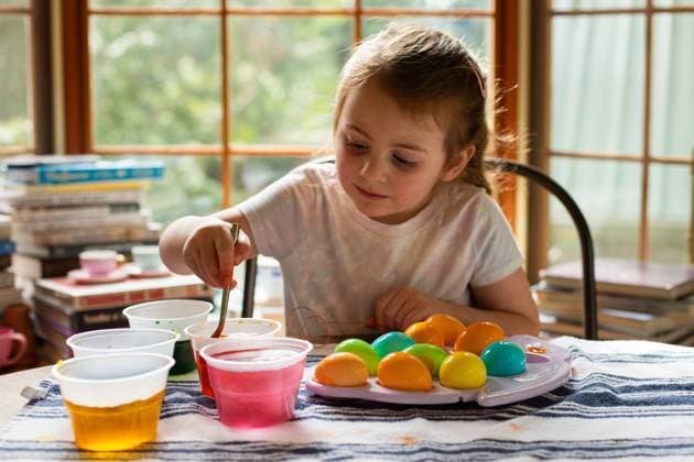 Little girl smiling and dyeing Easter eggs Seattle, Washington, United States CR_AAGC240229-1359997-01 ,model released, Symbolfoto