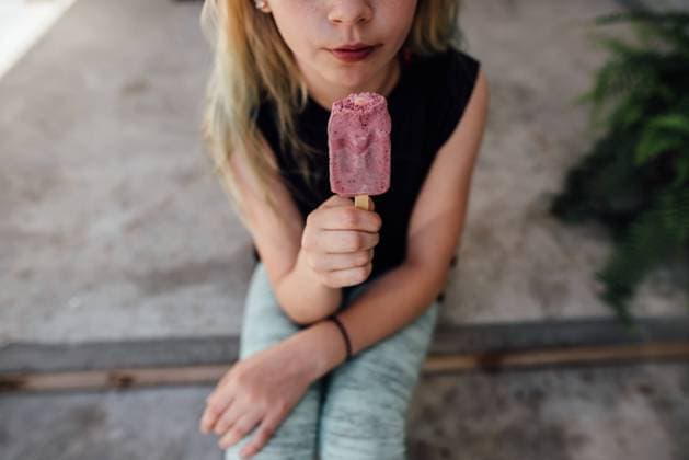 Creative Highlights Symbolbilder Detail shot of girl with popsicle on steps outside in summer. Bismarck, North Dakota, United States CR_KIFR240228-1358207-01 ,model released, Symbolfoto