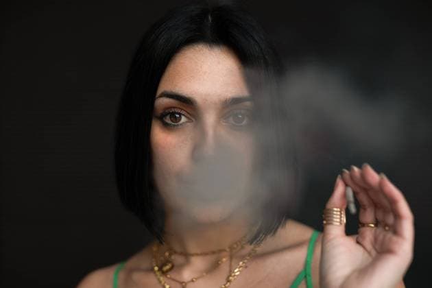 Creative Highlights Symbolbilder A contemporary portrait of a young woman exhaling smoke, with Madrid s Four Towers looming in the urban skyline behind her. Model Released PabloMenendez_ID19677_583464_018 Copyright: xPabloxMenendezx