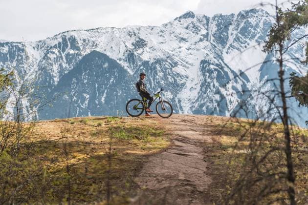 Woman mountain biking with mountains in the background Pemberton, British Columbia, Canada CR_ALEG2402238E-384580-01 ,model released, Symbolfoto