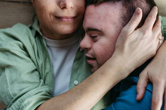 IMAGO Creative, Diversity, Mütter Portrait of young man with Down syndrome with his mother at home, holding, touching with foreheads. Concept of love and parenting disabled child. Close up. Portrait of young man with Down syndrome with his mother at home, holding, touching with foreheads. Concept of love and parenting disabled child. Close up shot. model released