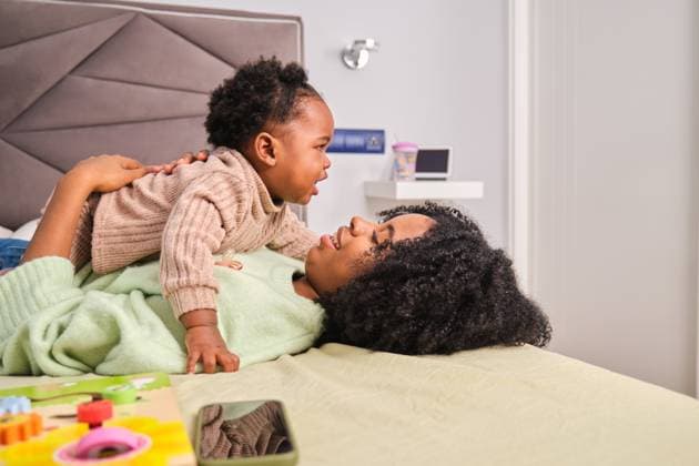 Cuban mother hugging her toddler daughter on bed at home. Madrid, Community of Madrid, Spain CR_CRVI240306-1363178-01 ,model released, Symbolfoto