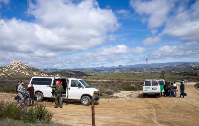 Migrants are placed into vans by the U.S. Border Patrol after crossing the border wall from Mexico near Campo, California, about 50 miles from San Diego, on Wednesday, March 13, 2024. A bipartisan Senate immigration bill to address the migrant immigration issue is stalled in the House due to election year politics.  CAL2024031353 PATxBENIC