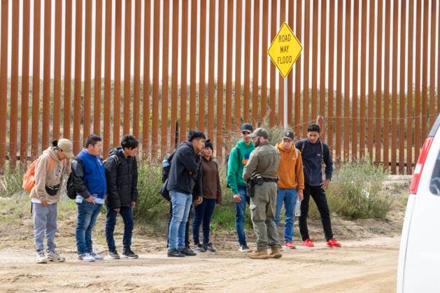 Migrants surrender to the U.S. Border Patrol after crossing the border wall from Mexico near Campo, California, about 50 miles from San Diego, on Wednesday, March 13, 2024. A bipartisan Senate immigration bill to address the migrant immigration issue is stalled in the House due to election year politics.  CAL20240313413 PATxBENIC