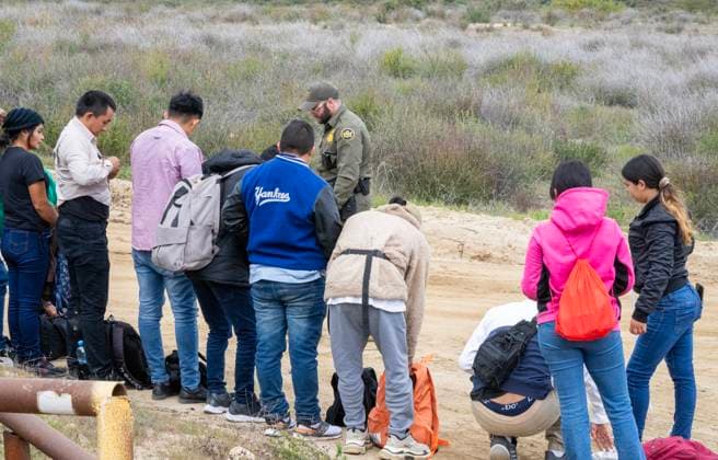 Migrants surrender to the U.S. Border Patrol after crossing the border wall from Mexico near Campo, California, about 50 miles from San Diego, on Wednesday, March 13, 2024. A bipartisan Senate immigration bill to address the migrant immigration issue is stalled in the House due to election year politics.  CAL2024031414 PATxBENIC